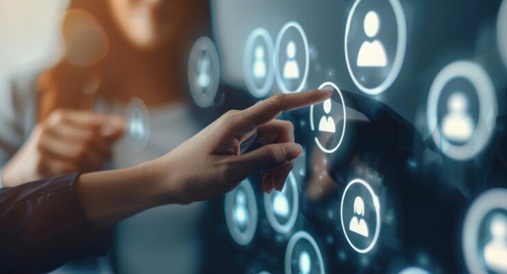 Eine Frauenhand tippt auf einem großen Touchscreen ein Icon mit Personensymbol an